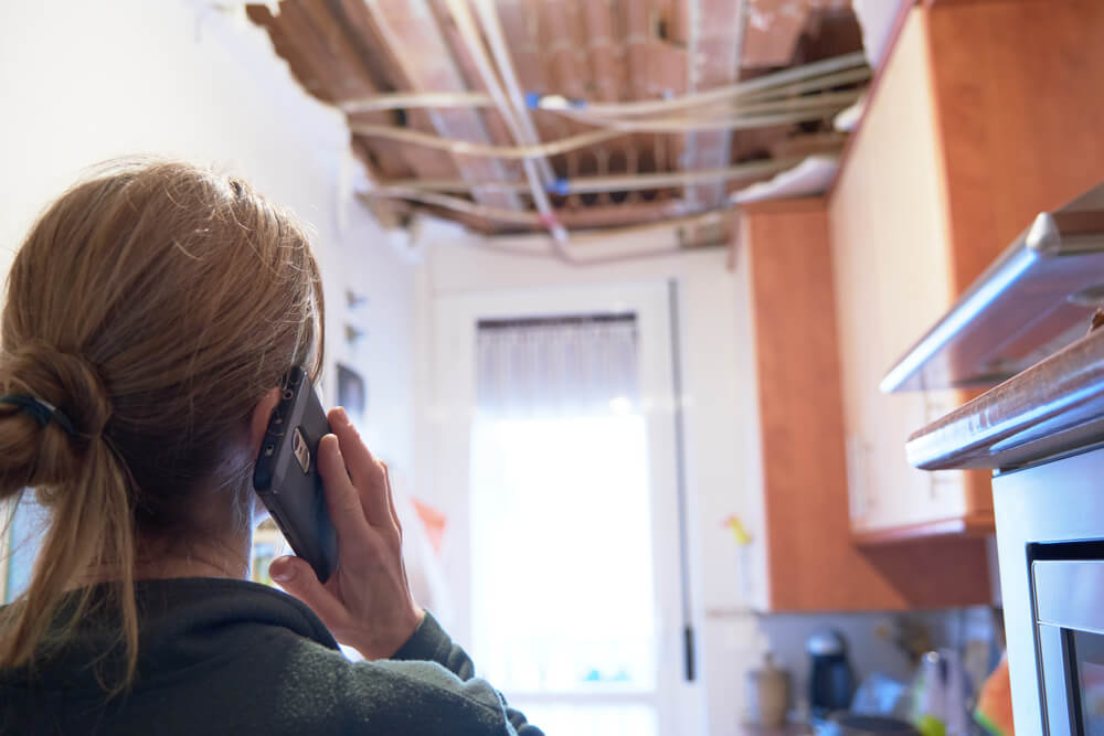 Woman explaining to her homeowner's insurance company that her apartment ceiling collapses.